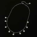 Elegante collar de flecos con perlas plateadas sobre un fondo negro minimalista - Collar de Plata (B-561) / Plateado
