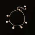 Detalle de una pulsera dorada con perlas blancas brillantes y diseño de cadena de eslabones - Pulsera Dorada (B-561) / Dorado