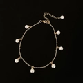 Dettaglio di un bracciale a catena dorata con diverse perle finte bianche pendenti - Cavigliera Dorata (B-561) / Oro