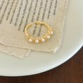 Detail of elegant gold open ring with five white pearls and sparkling rhinestones - Gold