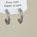 Eleganti orecchini a cerchio a C in argento con micro-pave di zirconi su cartoncino bianco - Orecchini a Bottone in Zirconia Argentata