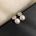 Macro view of elegant pearl studs featuring silver discs on textured black and white wool - Silver Mirror White Pearl
