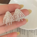 Silver bead tassel drop earrings with cascading chains shown on hand in a luxury style - Silver