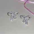 Detailed view of silver bow earrings with micro-pave cubic zirconia on a minimalist background - Silver Zircon Bow