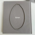 Vista de detalle de collar de perlas gris metalizado 6mm con cierre industrial minimalista - Estilo 6mm / Gris