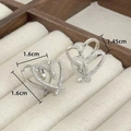 Detail of silver heart earrings with white cubic zirconia inlay on jewelry box - Silver