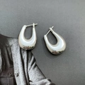 Dettaglio di orecchini a cerchio a forma di U in argento lucido su sfondo grigio - Orecchini a forma di U argento / Argento