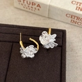 Detalle de pendientes de botón con forma de flor en oro y plata en un soporte - Pendientes de Botón de Flor Bicolor