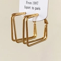 Macro detail of gold layered geometric square earrings on white display card - Gold Square