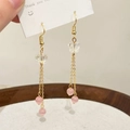 Detailansicht goldener Quastenohrringe mit Schmetterlingsmotiven und rosa Katzenaugen-Perlen - Rosa
