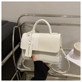Detail of white textured leather crossbody bag with top handle and metal buckle strap - White