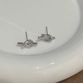 Detail view of silver knot stud earrings with S925 sterling silver stamp on the pin - Silver
