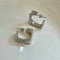 Macro shot of silver geometric square hoop earrings with polished metal finish - Square Silver Earrings