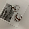 Dettaglio di orecchini a cerchio argento con trama martellata irregolare e finitura metallica - Orecchini a cerchio plissettati argento