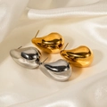 Dettaglio di orecchini a goccia in oro e argento su seta bianca con finitura lucida - Oro