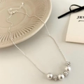 Elegante collar de plata con tres perlas y tres bolas de cristal en una cadena fina - Plateado