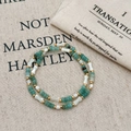 Dettaglio della collana con perle verdi tonde, perle bianche a forma di osso e inserti dorati - Bracciale (B-541)