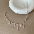 Vista dettagliata della collana nappa argento con perle su sfondo opaco - Bracciale con nappa d'argento