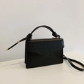Elegant black crocodile pattern crossbody bag with a unique knot handle and gold hardware - Black