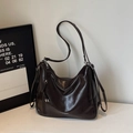 Dunkelbraune Schultertasche aus Öl-Wachs-Leder mit glänzendem Finish und Quastendetail - Braun