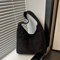 Bolso hobo minimalista de pana negra con parche de moda en una escena de luz natural - Negro