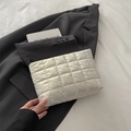 Neceser acolchado blanco con diseño de rejilla y cremallera negra sobre blazer negro - Blanco