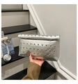 Detail of silver metallic rivet handbag featuring industrial stud patterns and snap closure - Silver