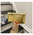 Close-up of gold metallic clutch bag with silver stud details and envelope flap closure - Gold