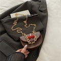 Brown semi-circle saddle bag with cherry decor and gold chain strap on a blazer - Brown