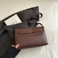 Dark brown minimalist envelope shoulder bag with metal rotary lock in a lifestyle setting - Brown