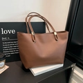 Minimalist caramel brown leather tote bag with gold metal hardware and sleek design - Brown