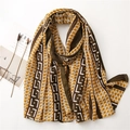 Détail d'écharpe avec motifs géométriques en jaune moutarde et bordures marron - Kaki