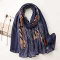 Detail of blue scarf with animal prints and wavy patterns on a minimalist table - 180cm x 90cm / Blue