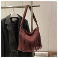 Dettaglio della borsa bordeaux con frange, texture in morbida pelle e stile urbano - Rosso