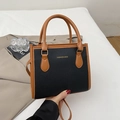 Chic black lychee grain leather crossbody bag with brown handles and gold logo detail - Black