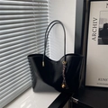 Minimalist black faux leather tote bag with unique curved top and golden bell charm detail - Black (With Pendant)