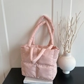 Rosa gesteppte Puffer-Tasche mit Karomuster auf einem minimalistischen Buchständer - Rosa