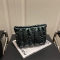Borsa a nuvola trapuntata nera minimalista con cuciture verticali su un libro d'arte - Verde