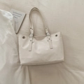 Cream-colored minimalist tote bag with silver rivets and adjustable shoulder strap - White