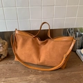 Brown matte suede tote bag with leather straps on a wooden surface for daily commute - Brown
