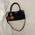 Black suede tote bag with decorative metal buckle and colorful pompom charm on white cloth - Black (With Charm)