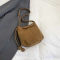 Braune Beuteltasche aus mattem Leder mit Kordelzug und dekorativen runden Anhängern - Braun