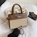 Brown leather and beige woven crossbody bag with gold metal lock in a lifestyle setting - Brown