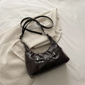 Dark brown hobo shoulder bag with silver buckle on a beige blazer stylish background - Brown