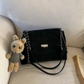 Minimalist black matte crossbody bag with silver buckle and cute bunny charm on a sofa - Black (With Charm)