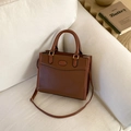Brown leather square handbag with twin handles displayed on a cream fabric sofa - Dark Brown