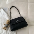 Dettaglio della borsa tote nera opaca con chiusura metallica e tracolla in pelle e catena - Nero Con Pendente