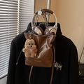 Deep brown oily leather bucket bag with chain strap and plush dog pendant - Brown / With Pendant