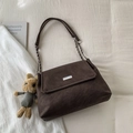 Dettaglio di una borsa tote in pelle scamosciata marrone con fibbia e ciondolo a coniglio - Caffè Con Pendente