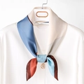 Elegante sciarpa in seta con motivo geometrico color-block su una camicia bianca - Blu